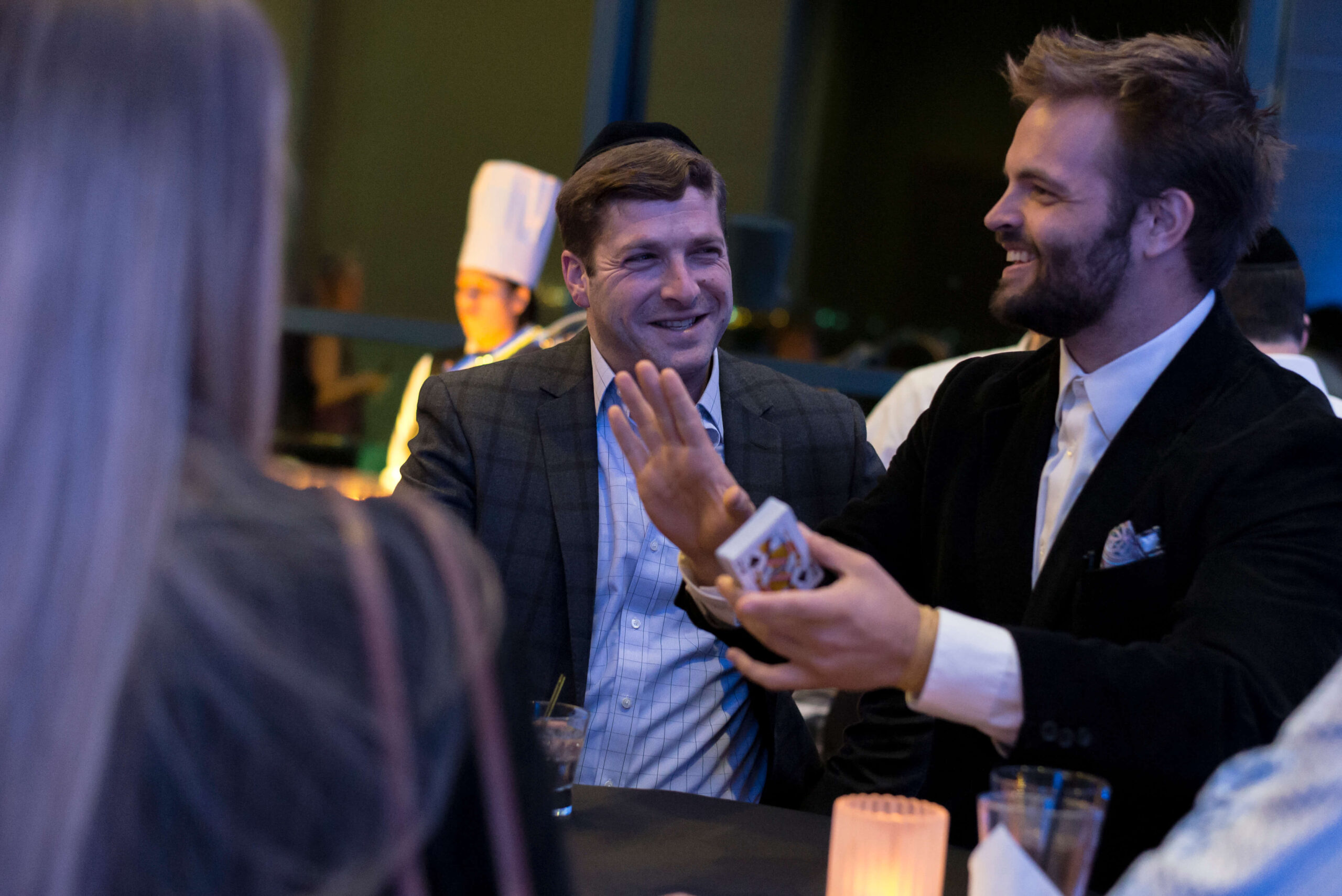 Kent Axell high-fiving a guest at a gala dinner table