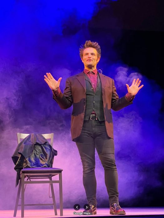 Kent Axell on stage under purple light