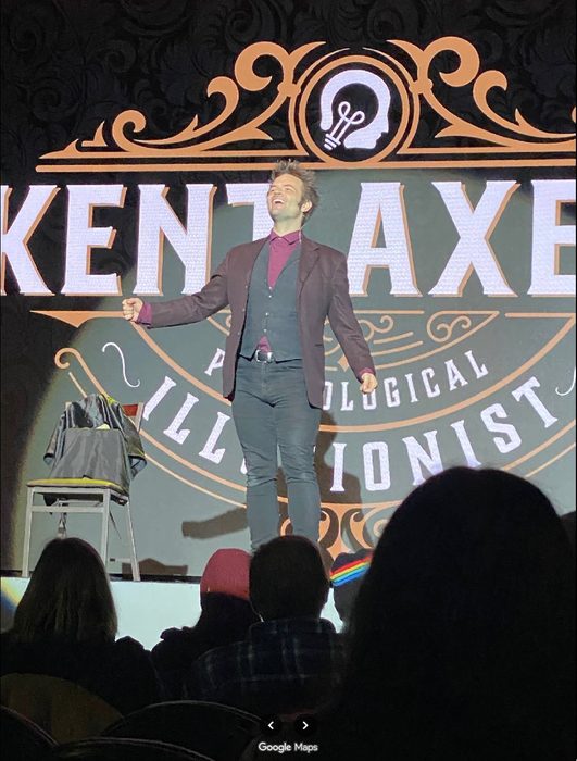 Kent Axell on stage in front of his illuminated backdrop