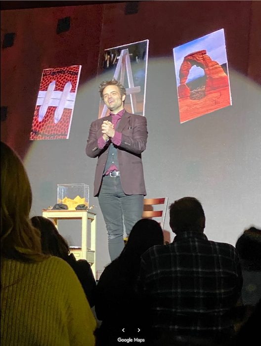 Kent Axell performing to a seated theatre audience