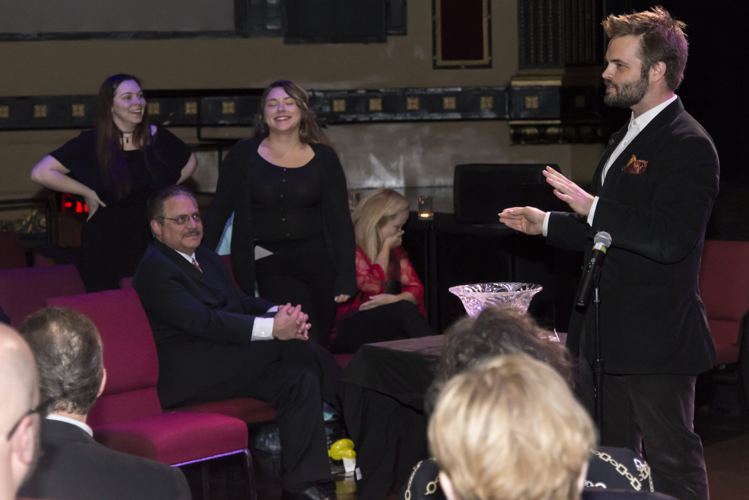 Kent Axell performing with volunteers on a theatre stage