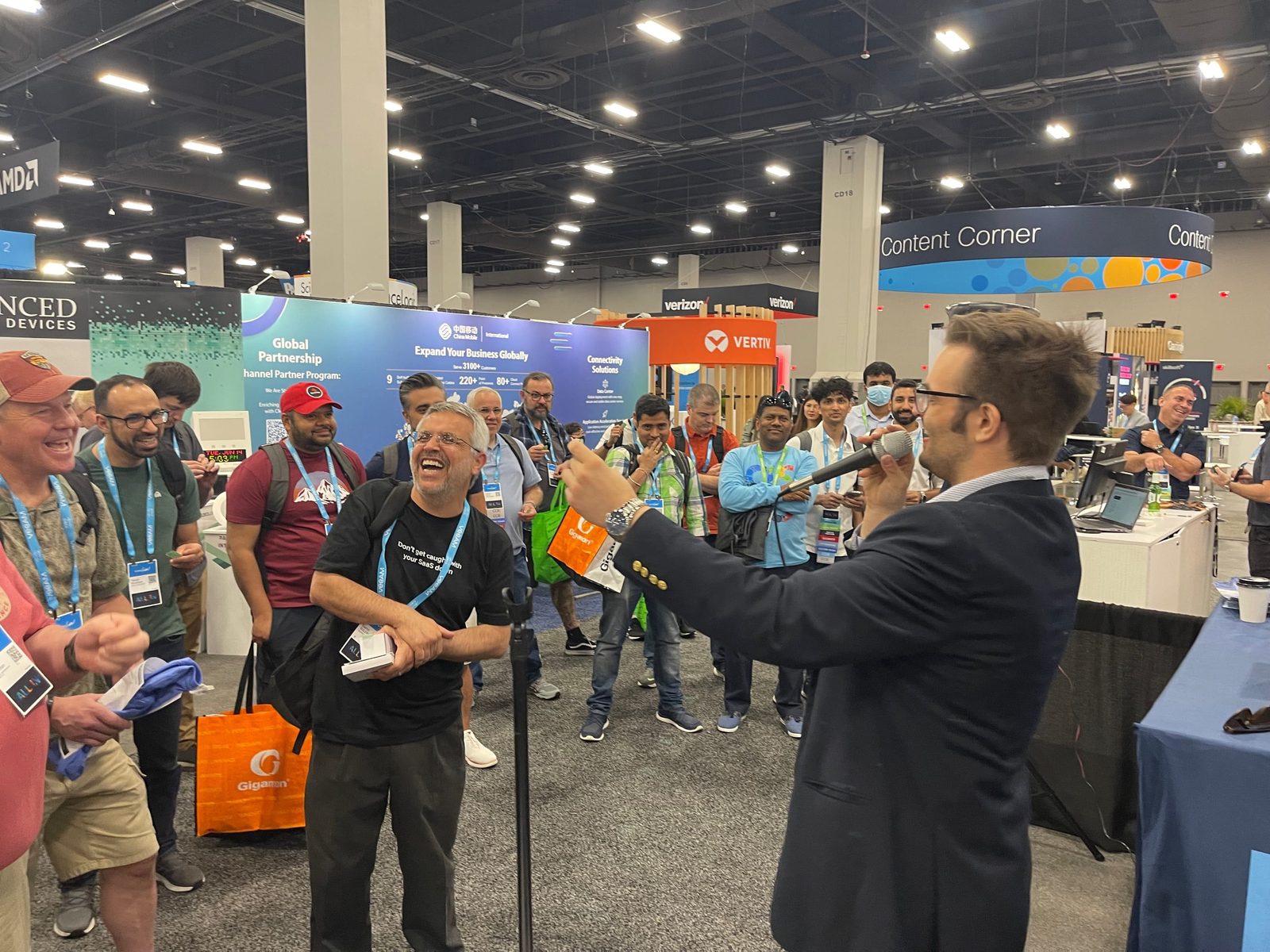 Kent Axell drawing a crowd with a microphone on a trade show floor